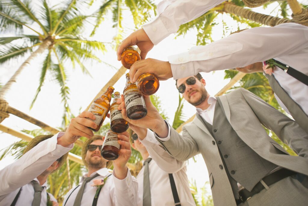 A group of groomsmen cheers beer at a destination wedding.