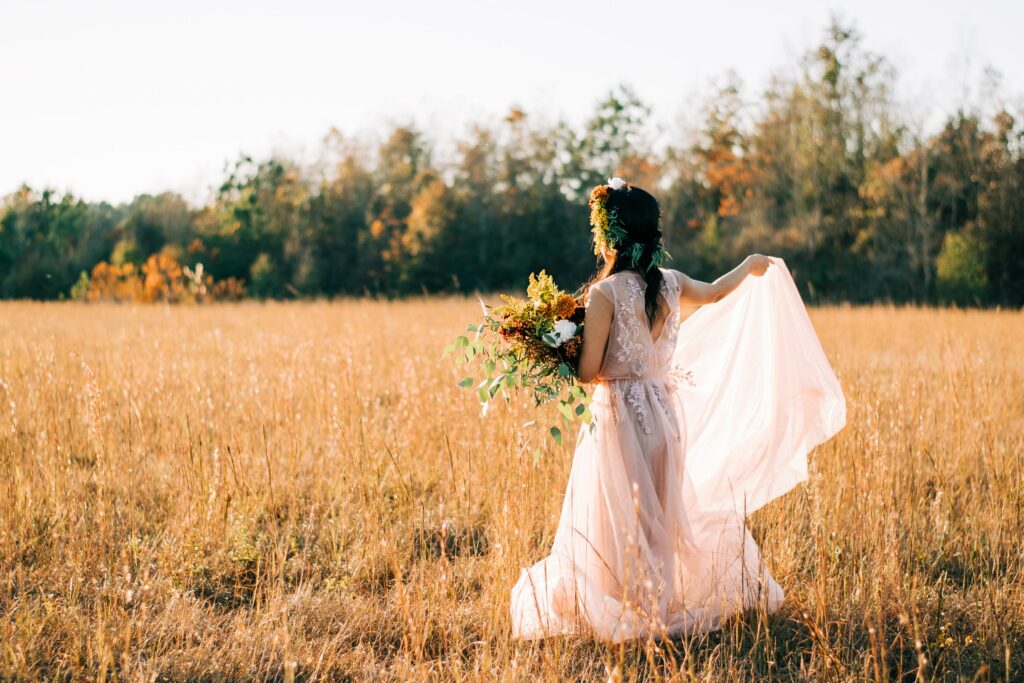 Bride in a Fall field with a wedding bouquet